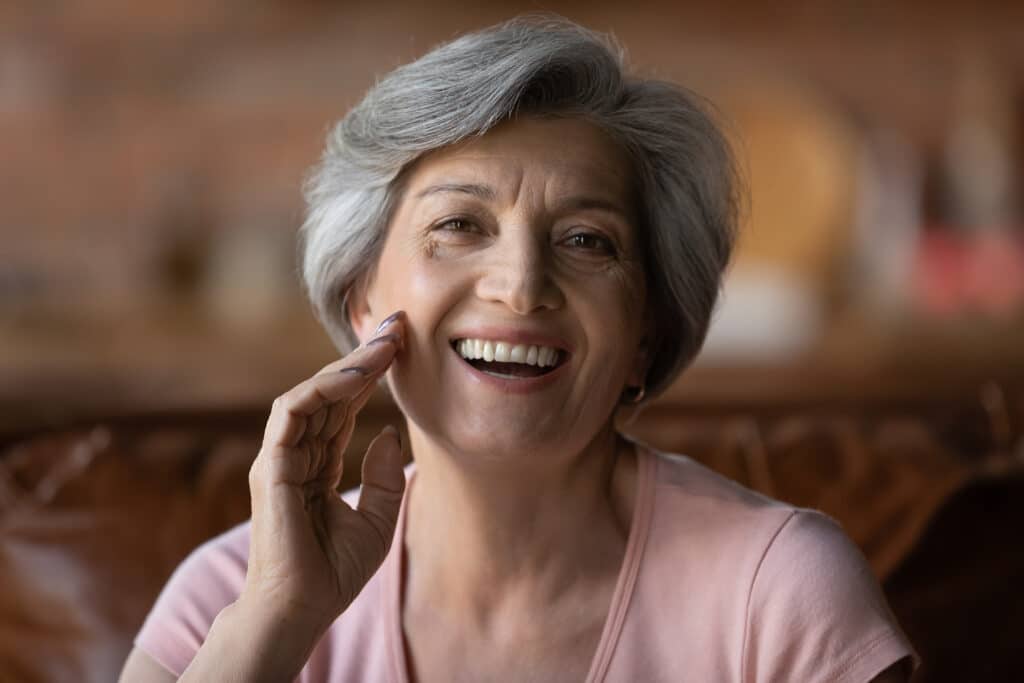 Mature woman smiling, happy with results after mohs reconstruction